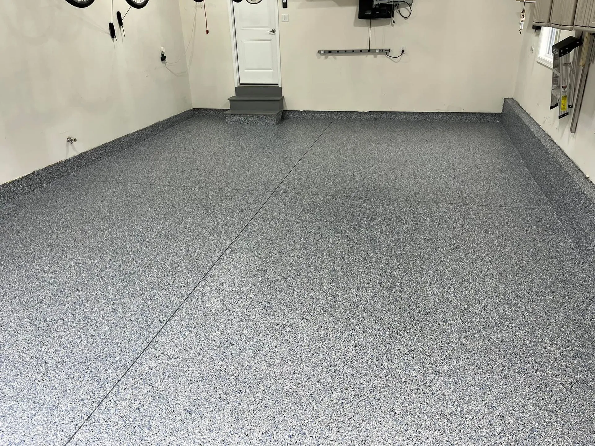 Finished light-colored garage floor with decorative epoxy flakes
